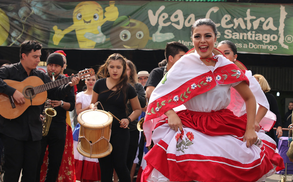 Migrants and natives dance at a multicultural celebration in La Vega, Chile.