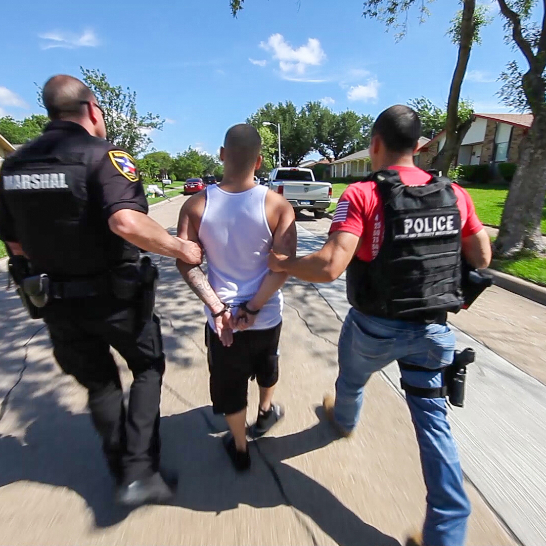 U.S. Immigration and Customs Enforcement (ICE) agents take a man into custody.