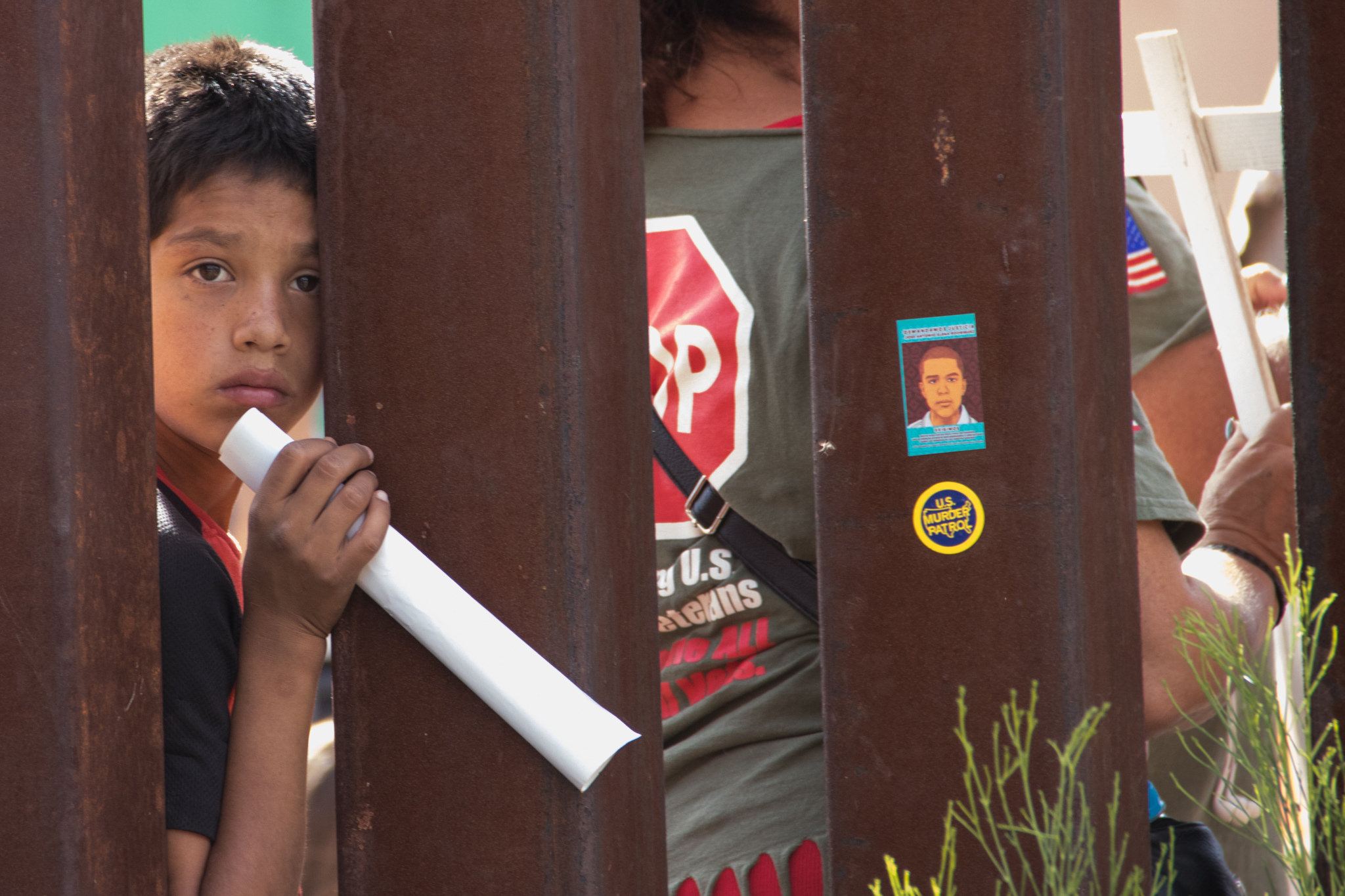 A boy peers through fencing at the U.S.-Mexico border. 