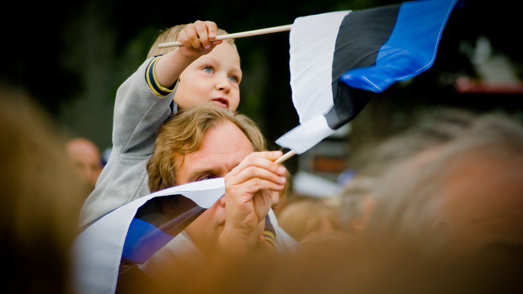 A father and son wave flags at the Estonian Song Festival in Tallinn.