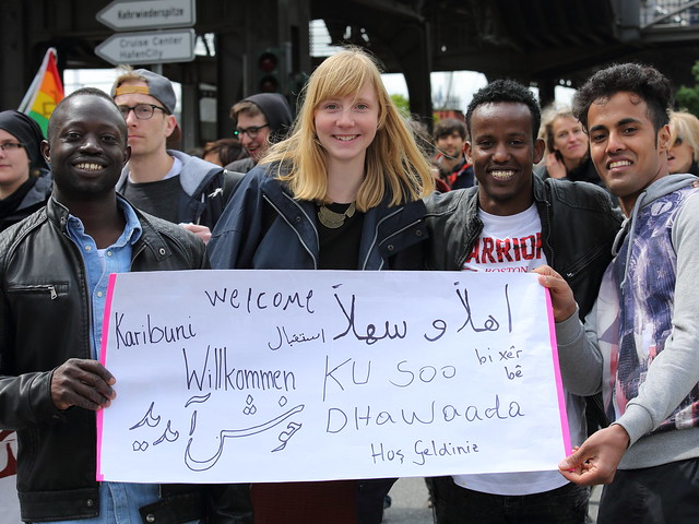Four people stand with a sign at a demonstration