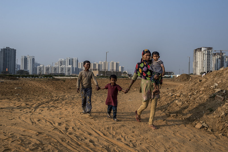 An Indian internal migrant walks with her children in Delhi