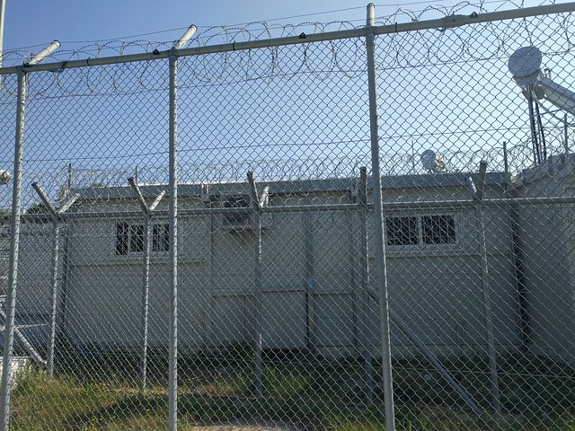 Buildings behind a barbed wire fence