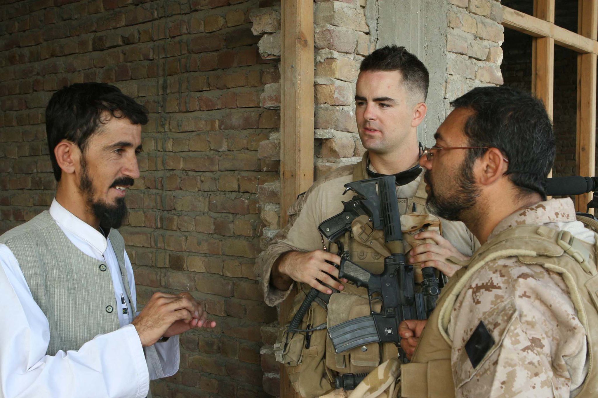 An Afghan man speaks to an interpeter working with the U.S. Marine Corps.