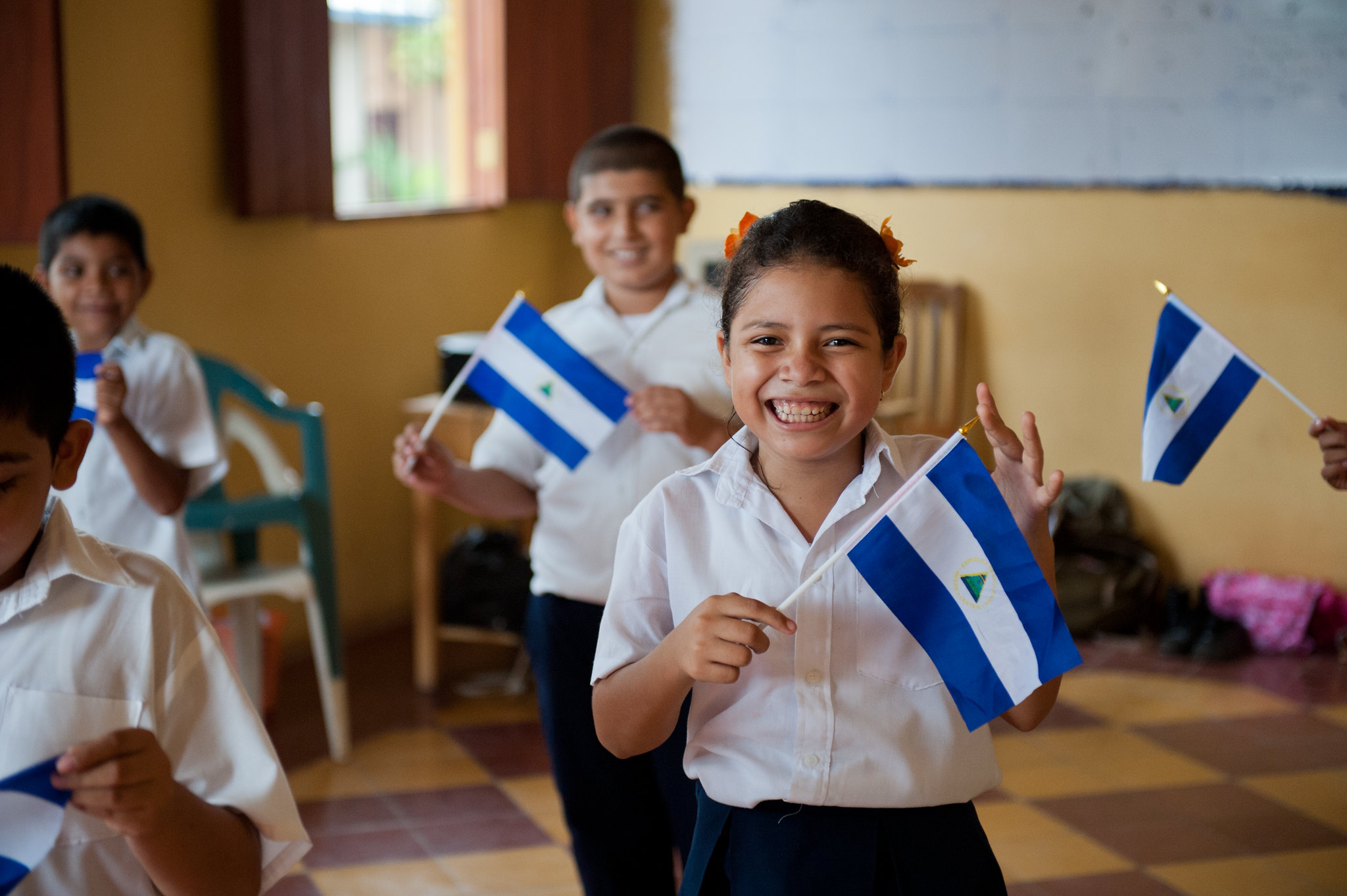 Niños nicaragüenses en la escuela sosteniendo la bandera de su país. 