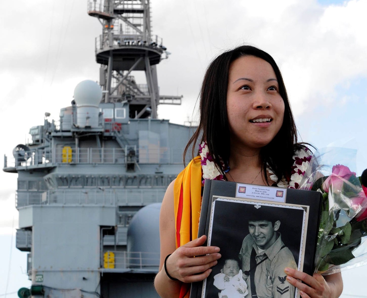 A woman stands onboard the U.S. Navy vessel on which she was born.