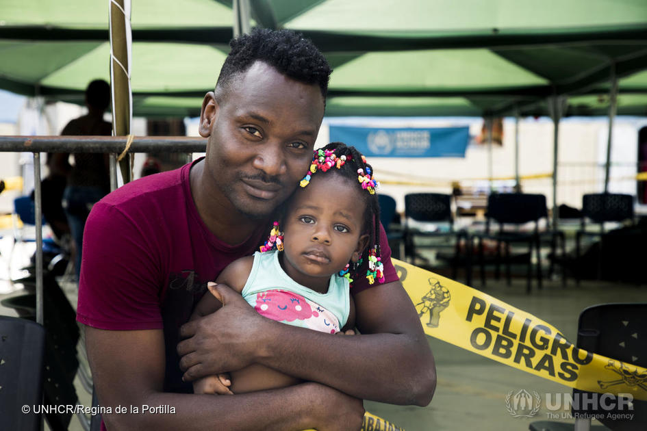 A Haitian man hugs his daughter in Peru.