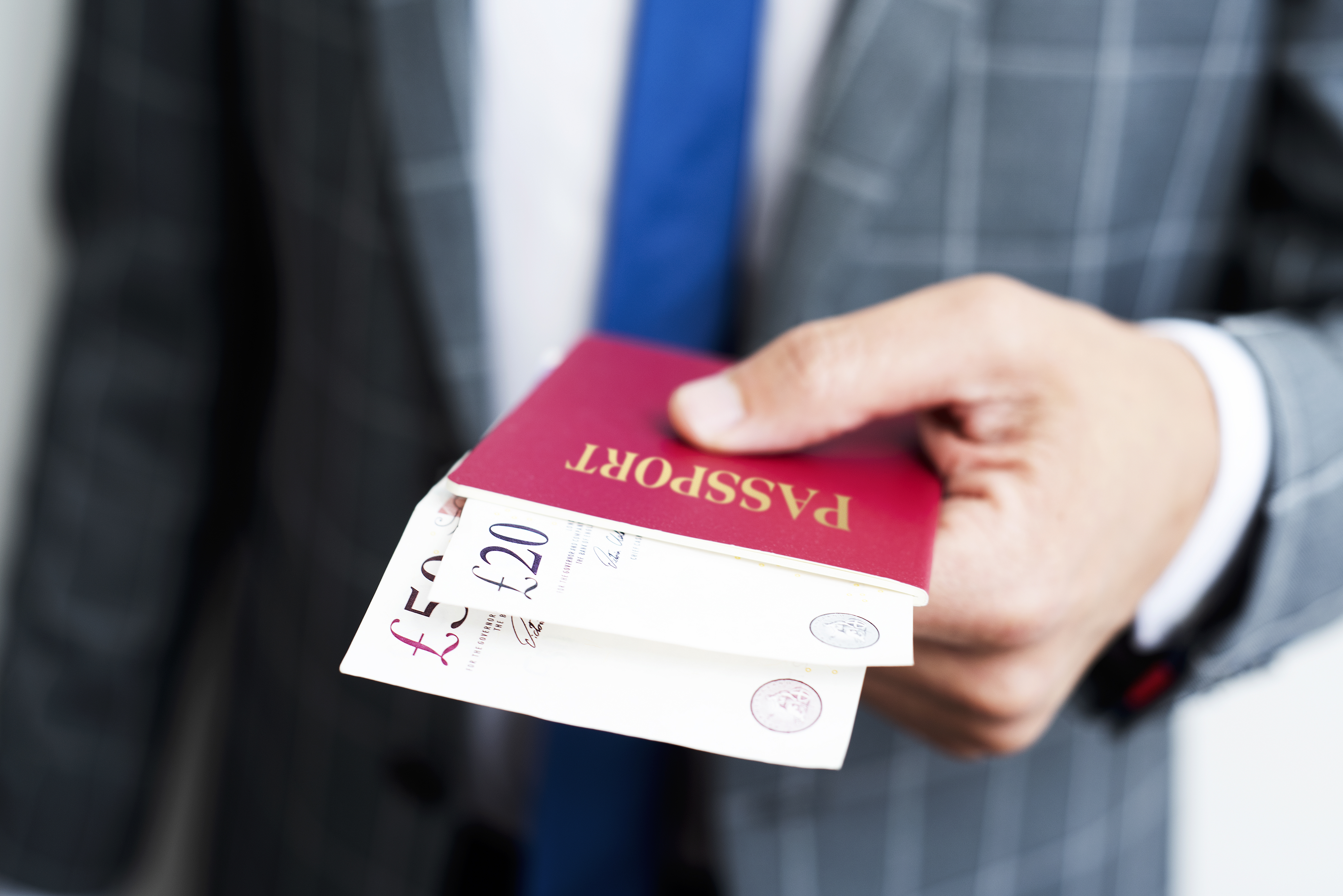 A man presents cash inside a passport