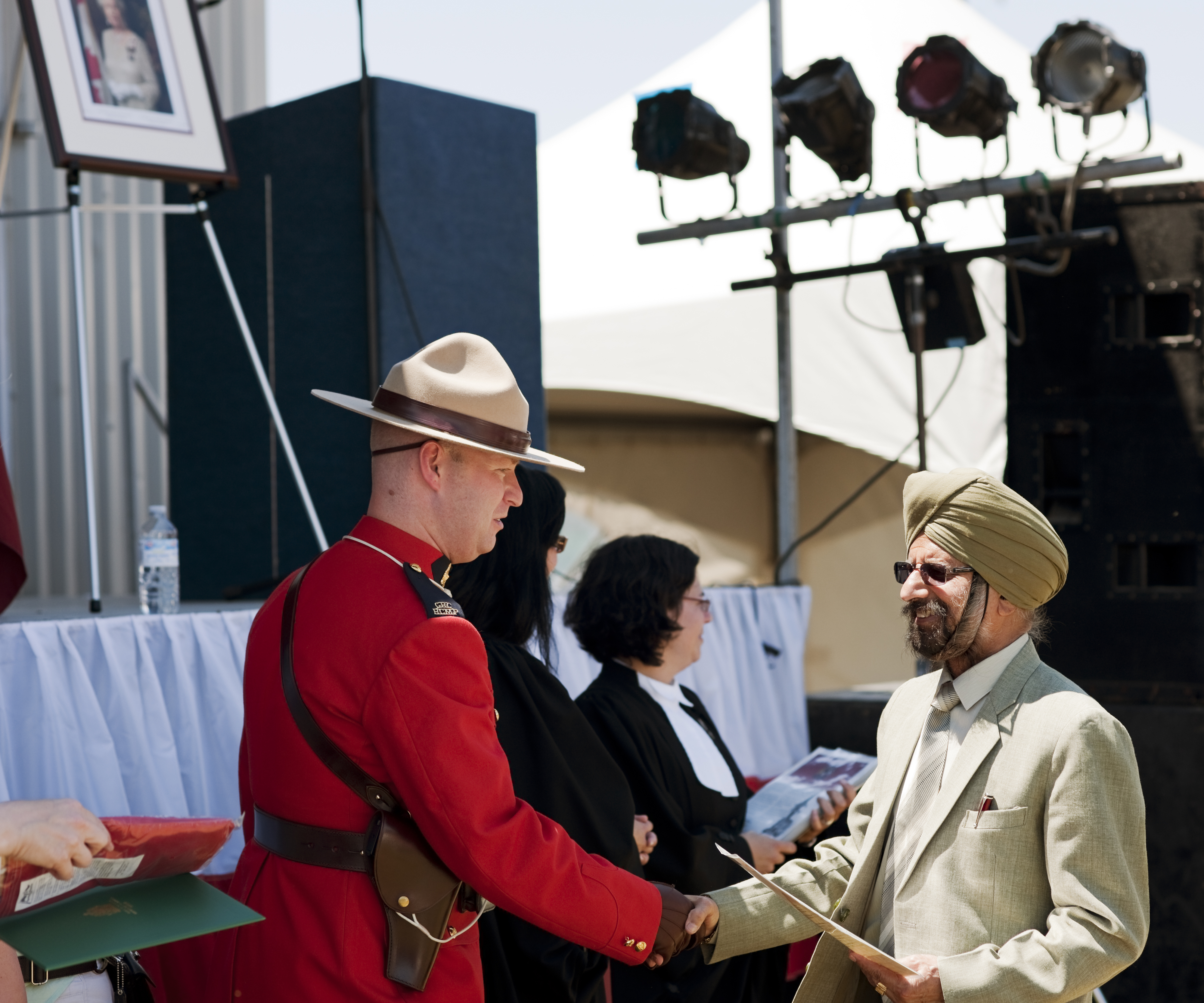 A new Canadian citizen greets a Royal Canadian Mounted Police officer at a citizenship ceremony