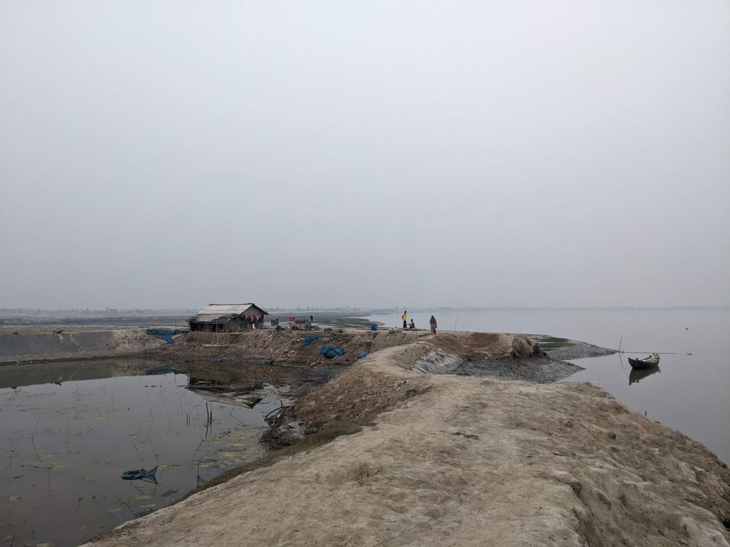 People walk along an embankment in Bangladesh