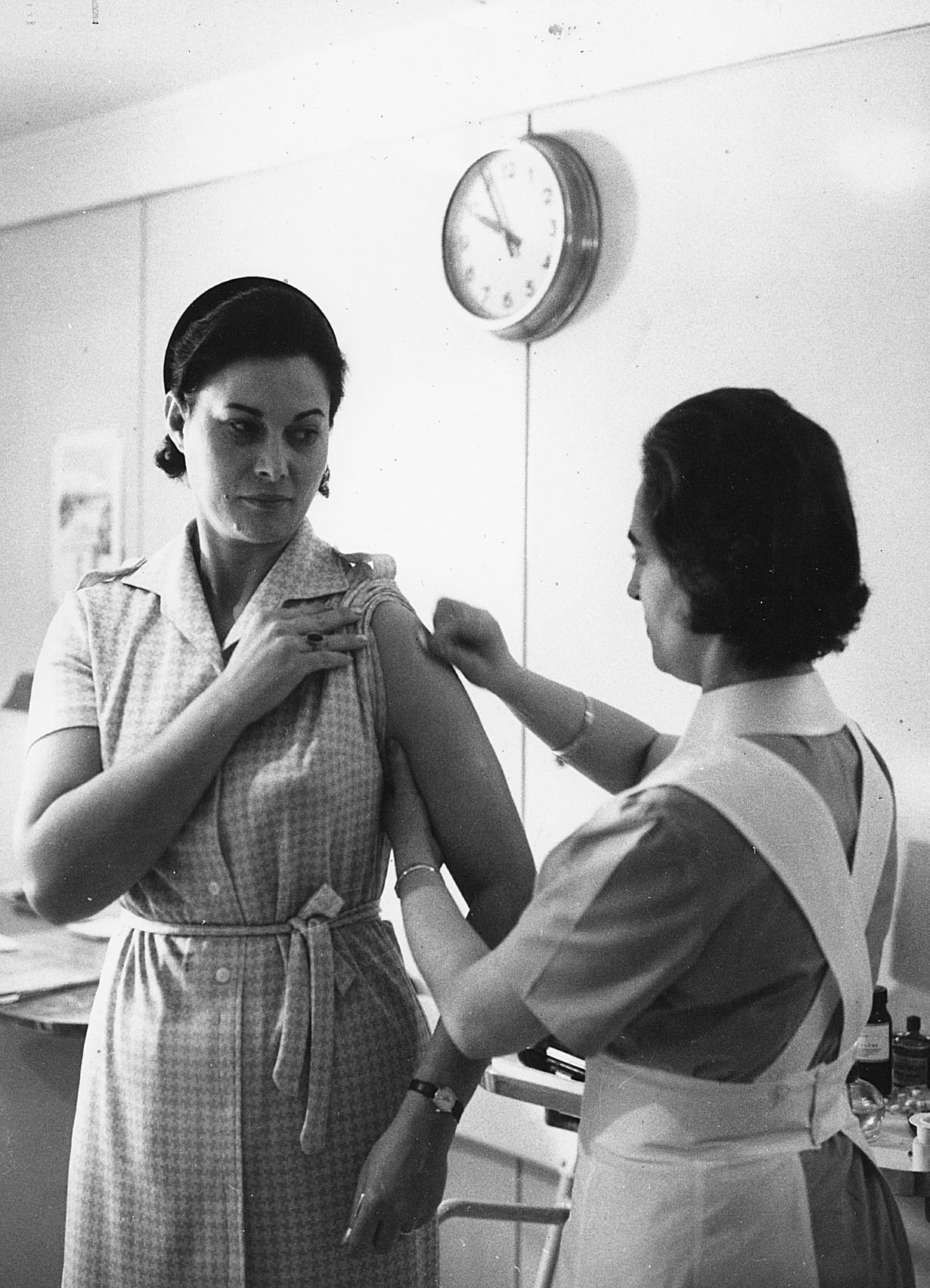 A woman in Italy is vaccinated before travel in 1951.