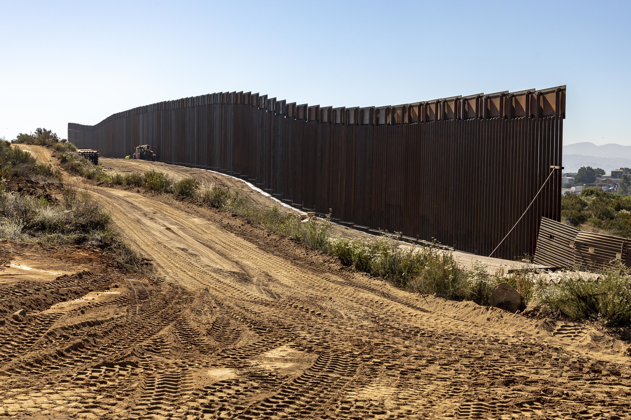 A construction crew works on a wall the U.S.-Mexico border.