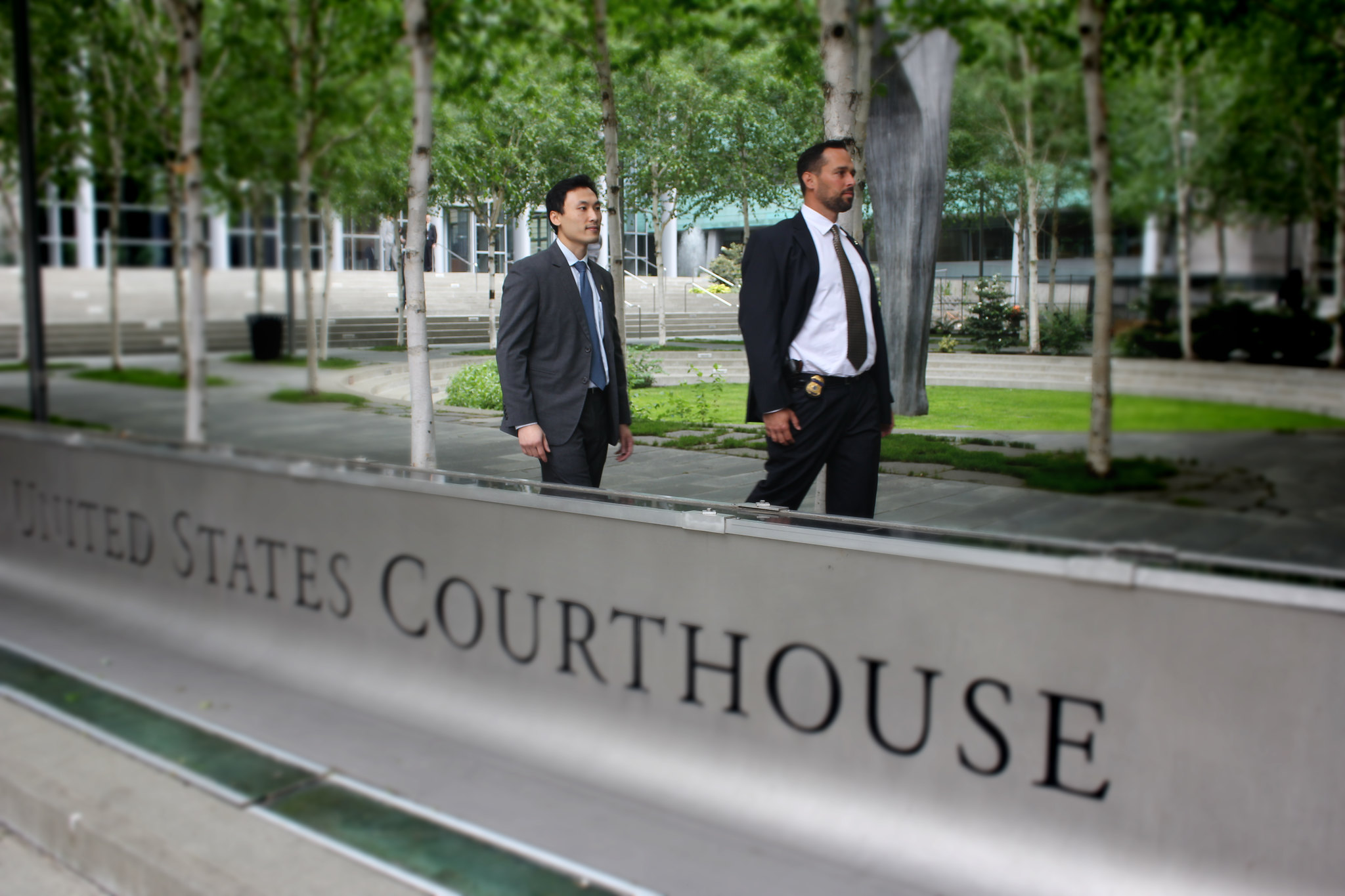 U.S. immigration officials walk by a courthouse in Seattle.