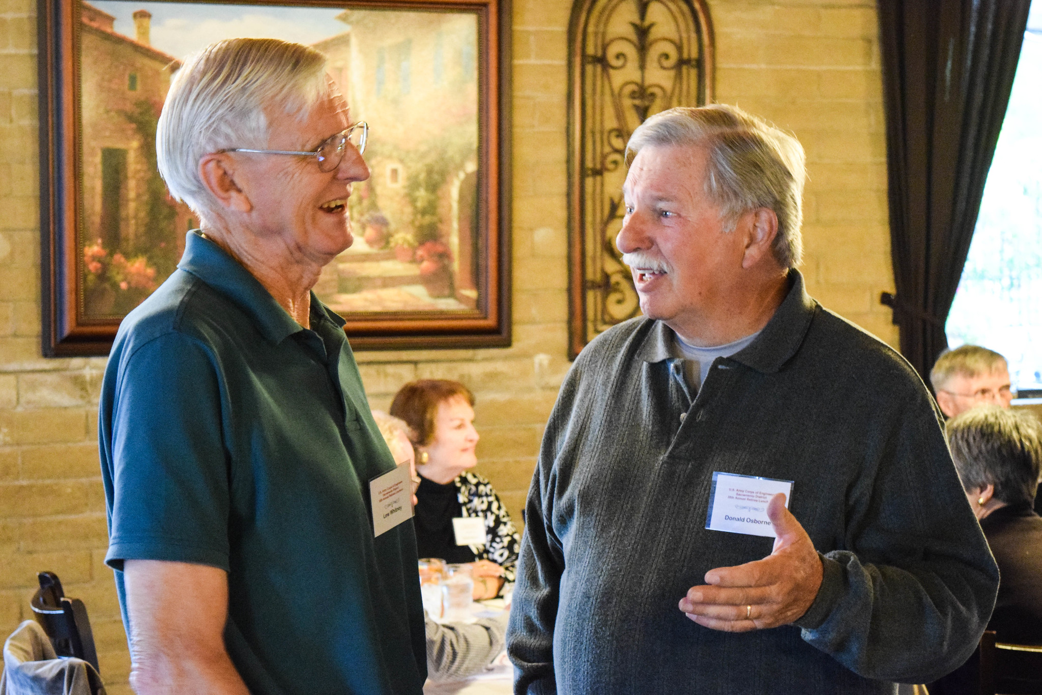 Two men talk during a retiree luncheon