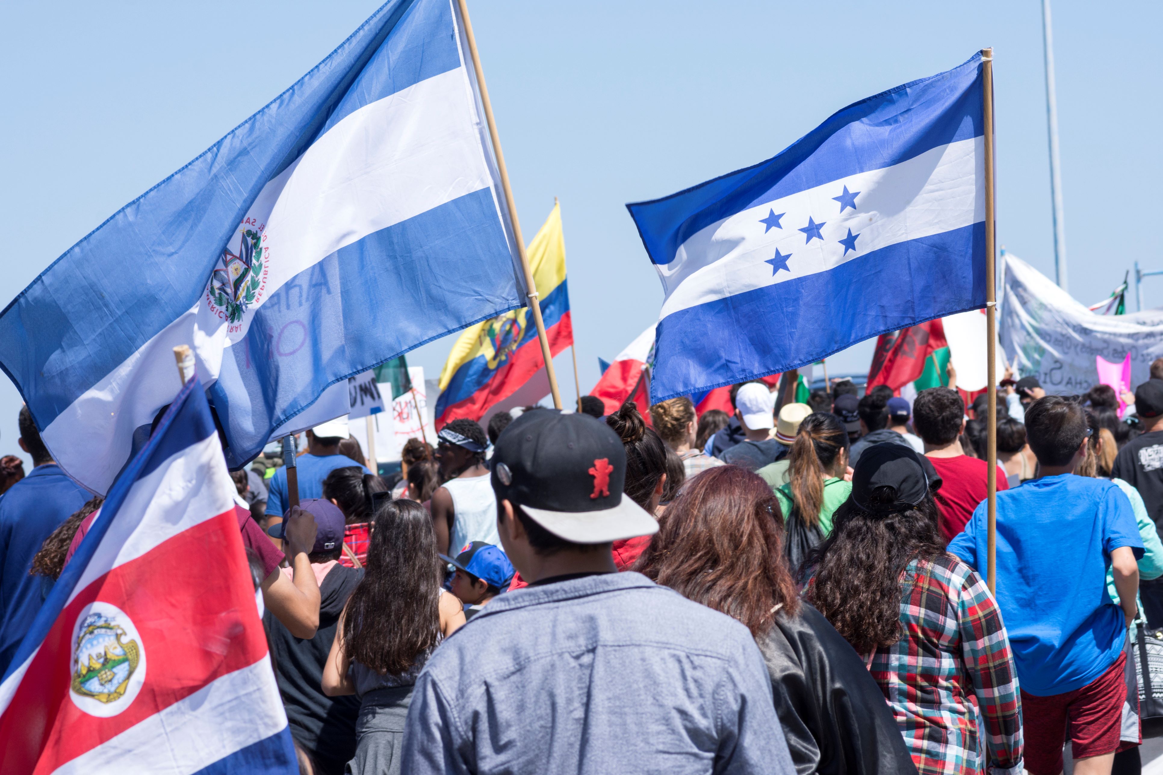 People hold flags of Central American nations at a march in San Diego.