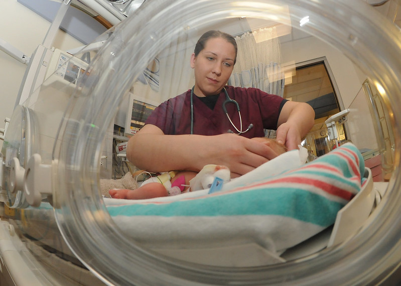 An intern examines a newborn baby in the Neonatal Intensive Care Unit.