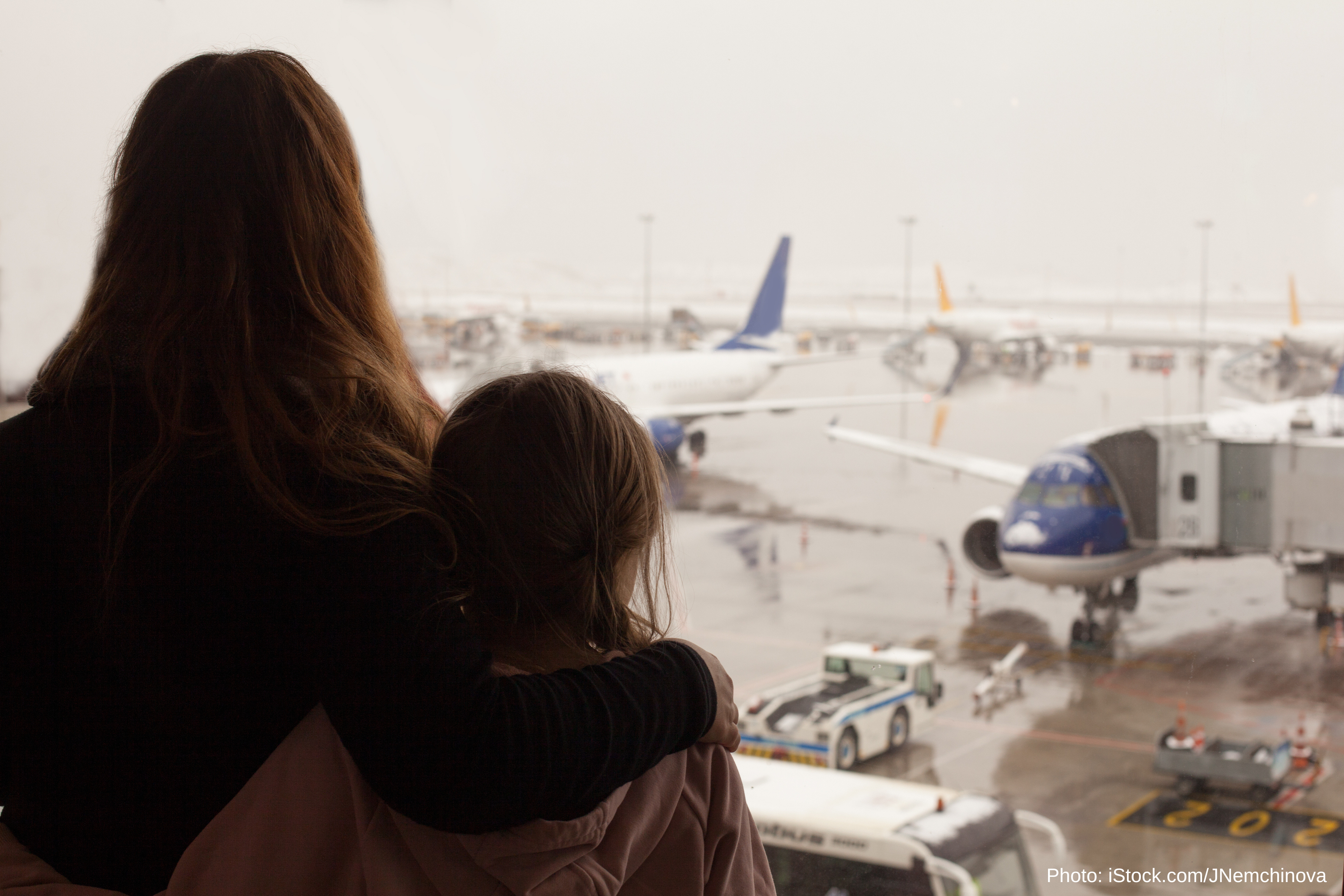A woman and child watch airplanes